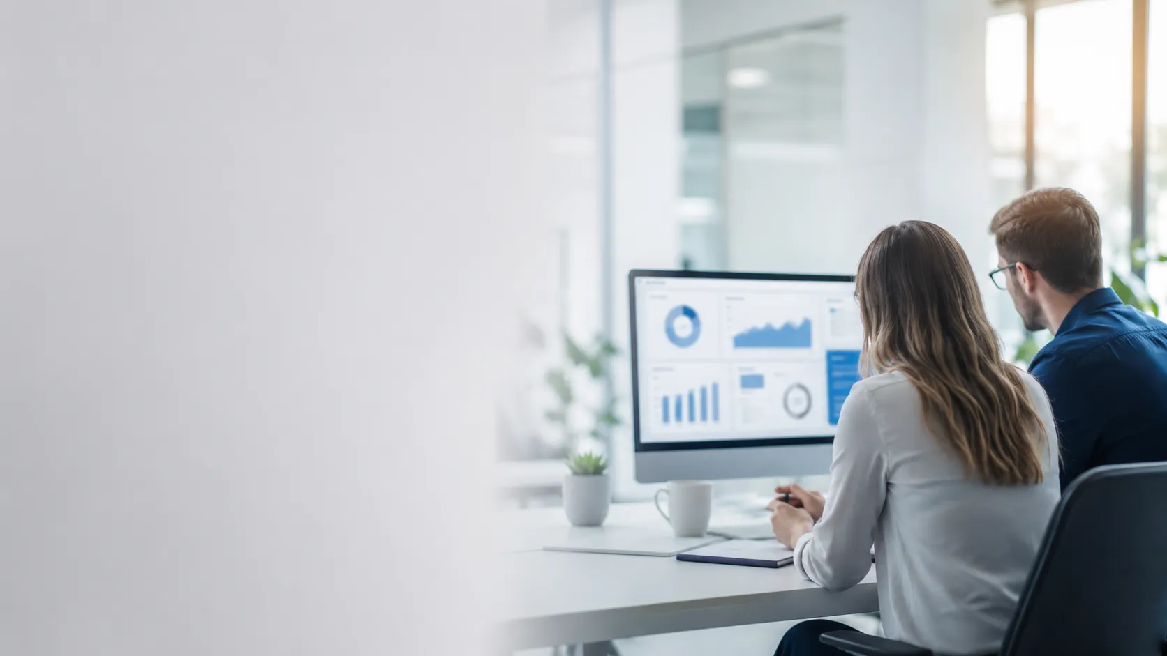 Two professionals reviewing dashboards together in a bright office